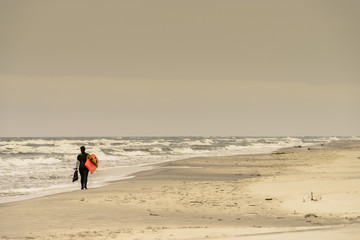 Fototapeta na wymiar Surfer walking on beach