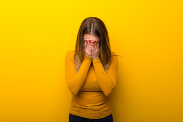 Young woman on yellow background with tired and sick expression
