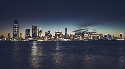 Fototapeta na wymiar Jersey City skyline at night, color toning applied, USA.