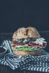 bread rolls topped with salami, salad, tomatoes