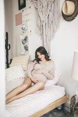 Beautiful young pregnant woman at home lying in bed