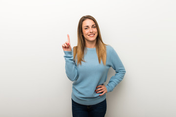 Blonde woman on isolated white background showing and lifting a finger in sign of the best