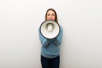 Blonde woman on isolated white background shouting through a megaphone to announce something