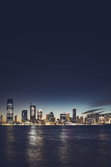 Fototapeta premium Jersey City skyline at night, color toning applied, space for text, USA.