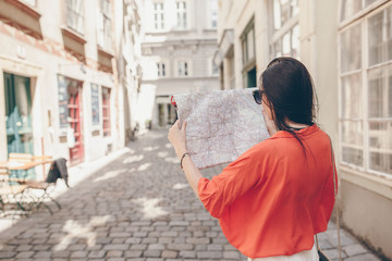 Young woman with a city map in city. Travel tourist girl with map in Vienna outdoors during holidays in Europe.