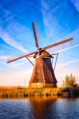 Fototapeta na wymiar Amazing nature, scenic sunset landscape, windmills, blue sky and water. Traditional dutch countryside, famous village of mills Kinderdijk, popular tourist attraction in Netherlands (Holland). Vertical