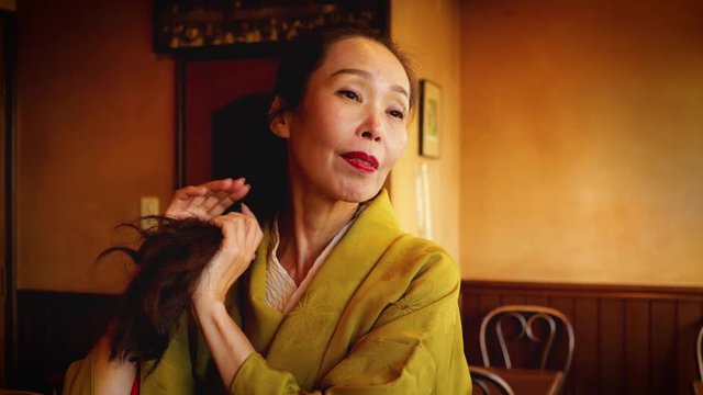 Elegant Japanese woman enjoying a coffee at a traditional Japanese coffee shop in Kyoto Japan.