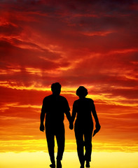 senior couple walking at sunset