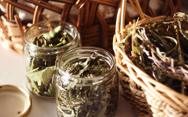 Dried Ivan-tea and other herbs are in jars and baskets