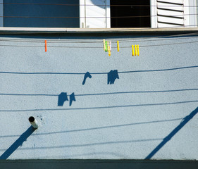 Clothespins on the ropes and their shadows. Old house in southern Tel Aviv (Israel). Everyday life.