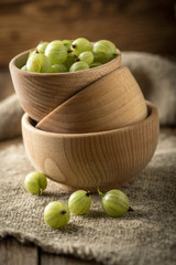 Fresh gooseberry in a wooden bowl.