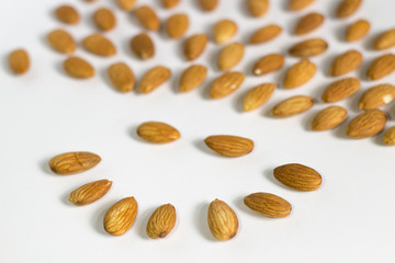 face from handful of almonds on white background