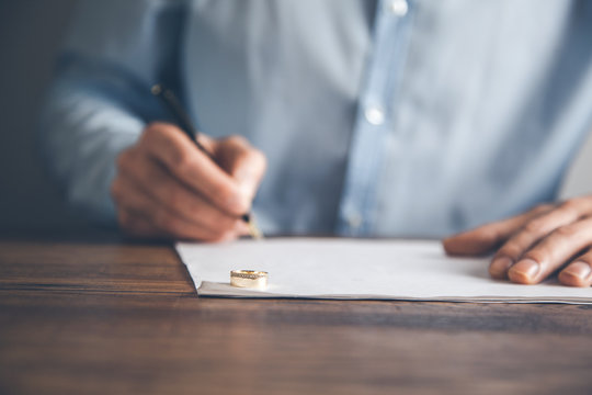 man hand document with wedding ring on desk