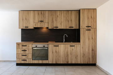 Modern wood kitchen in the apartment with white walls