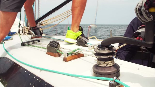 Two unidentified sailors work with ropes and marine equipment. Close view