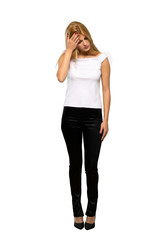 Young blonde woman with tired and sick expression over isolated white background