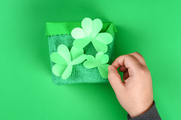 DIY leprechaun trap with gold coins, rainbow and green ladder St Patricks Day background.