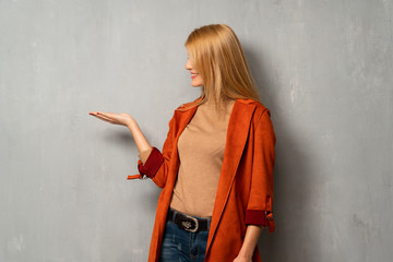 Woman over textured background holding copyspace imaginary on the palm to insert an ad