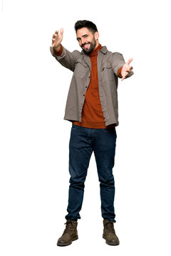Full-length shot of Handsome man with beard presenting and inviting to come with hand on isolated white background