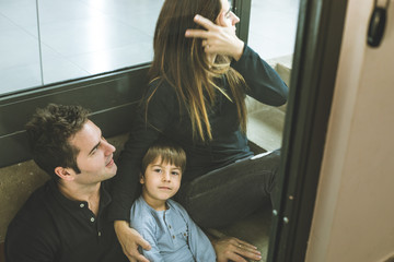 Family with happy son and smiling sitting on the stairs at home.Couple with a happy child playing