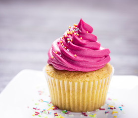 cupcakes with cheese cream and small decorative balls