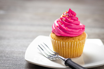 cupcakes with cheese cream and small decorative balls