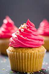 cupcakes with cheese cream and small decorative balls