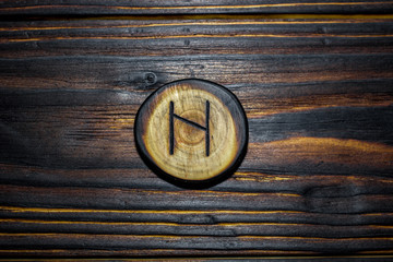 Rune Haglaz (Hagalaz) carved from wood on a wooden background - Elder Futhark