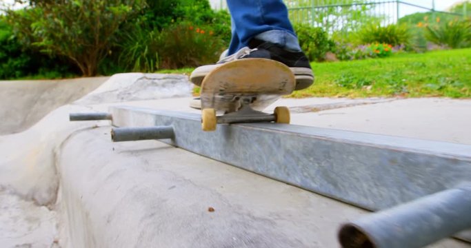 Close-up of young man practicing skateboarding on ramp in skateboard park 4k