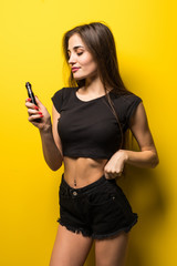 Young pretty woman with vape smoke gadget standing isolated on yellow background