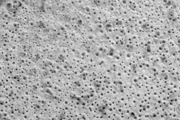 abstract spotty and porous organic texture closeup for a background or for wallpaper of white gray color