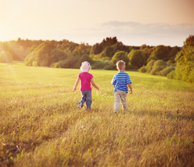 Boy and girl walking on the field in summer