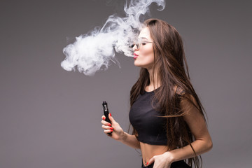 Close-up Portrait of sexy young woman with suglasses smoking vape isolated on gray background....