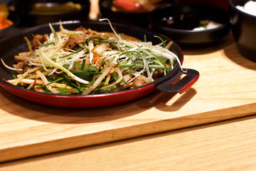 Asian cuisine, pan with meat close up, side view