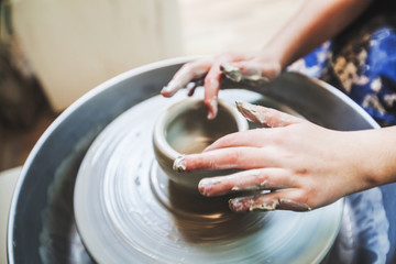 potter hands working with clay on pottery wheel