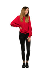 A full-length shot of a Young woman with red sweater suffering from backache for having made an effort over isolated white background