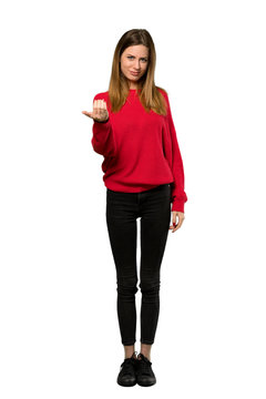 A full-length shot of a Young woman with red sweater inviting to come with hand. Happy that you came over isolated white background