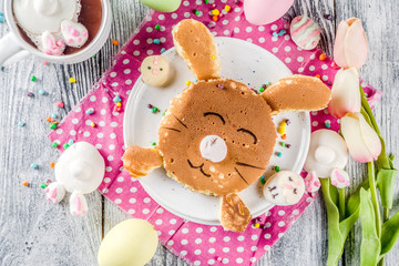Fototapeta na wymiar Funny easter breakfast food, kids pancake in form of bunny rabbit, with hot chocolate, top view wooden background copy space