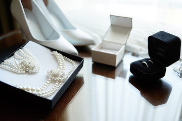 Luxury bride jewelry (pearls necklace and bracelet) and white women shoes, golden wedding rings in...