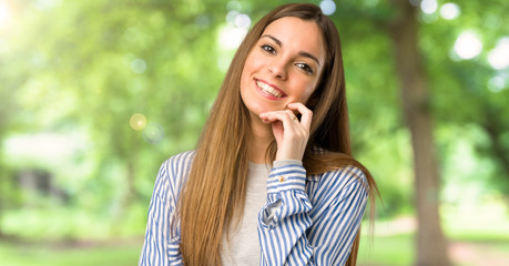 Young girl with striped shirt smiling with a sweet expression at outdoors