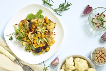 Roasted cauliflower with chickpeas, zucchini noodles and rosemary, salad, top view, copy space