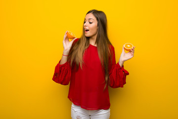 Young girl  on vibrant yellow background with oranges