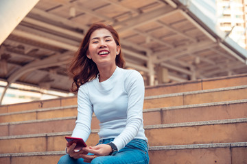 portrait of smiling young woman sitting on staircase