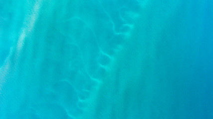 Sand, rock, and sea patterns on cristal clear waters.
