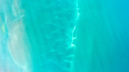 Sand, rock, and sea patterns on cristal clear waters.