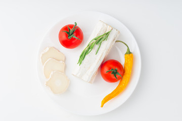 Tasty bushe cheese with rosemary and tomato, on white table