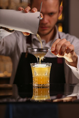 Fresh alcohol Penicillin cocktail with orange slice and ice cubes. Barmen making alcohol cocktail	