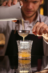 Fresh alcohol Penicillin cocktail with orange slice and ice cubes. Barmen making alcohol cocktail	