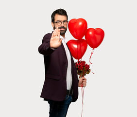 Man in valentine day making stop gesture denying a situation that thinks wrong over isolated grey...