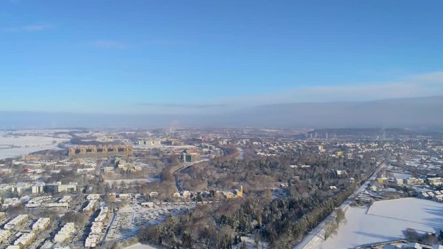 Flying and sinking over the snow covered german city of Aachen in the Eifel region